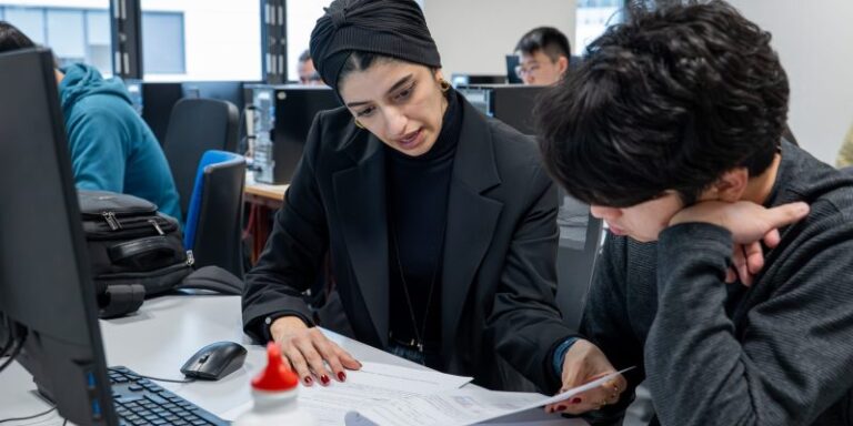 Two persons at a desk learning together